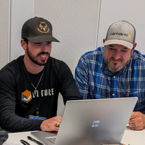 Two foremen looking at a laptop